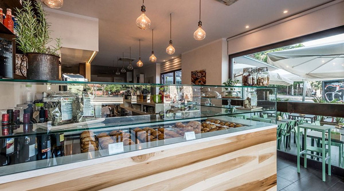 glass display case of baked goods in a modern sunlit restaurant.