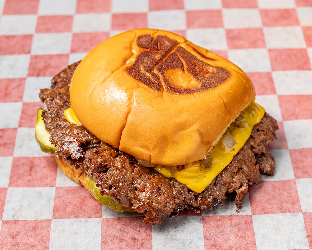 cheeseburger on a red and white checkered piece of paper.