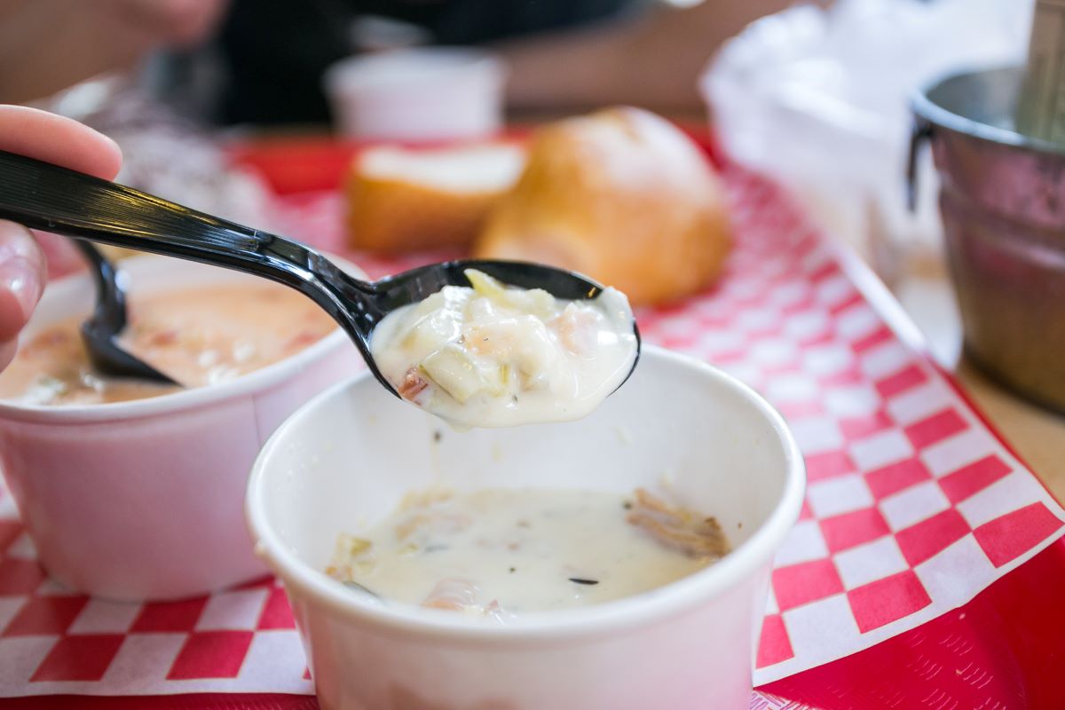 A person eating New England clam chowder in Boston. 