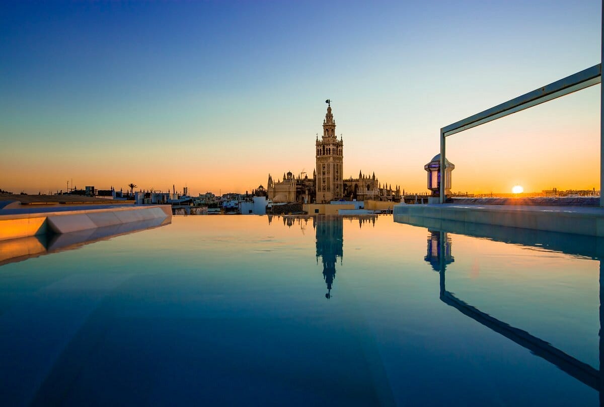 rooftop infinity pool overlooking the Seville cathedral at sunset.
