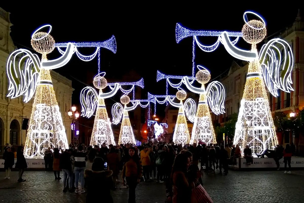 tall illuminated angels in a plaza in Seville.
