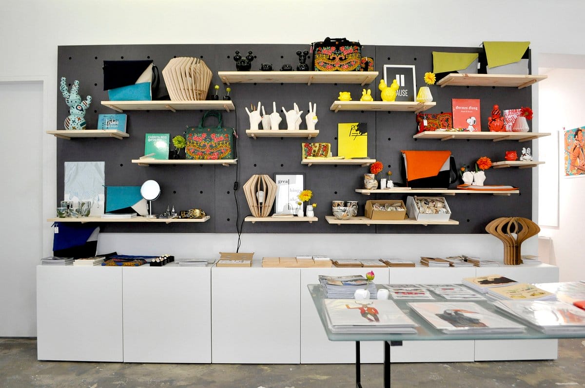 shelves of artwork, books, and sculptures in a gallery gift shop.