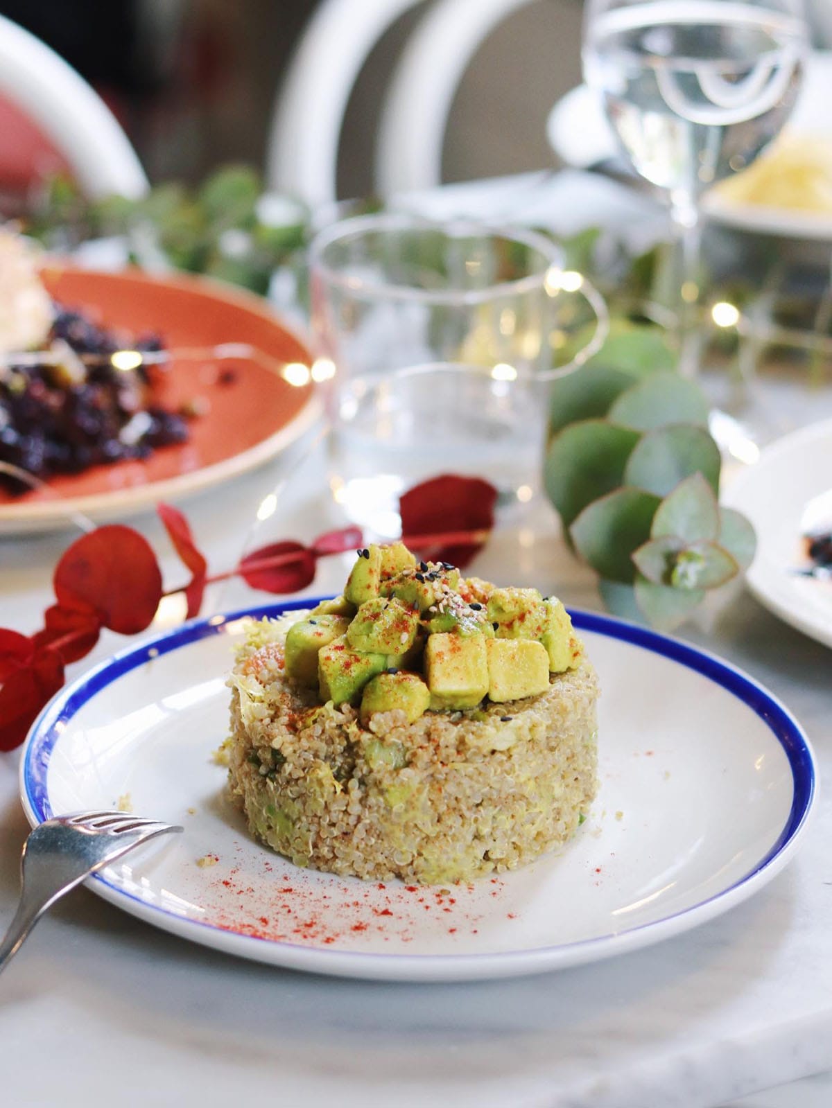 quinoa and avocado dish on a white and blue plate.