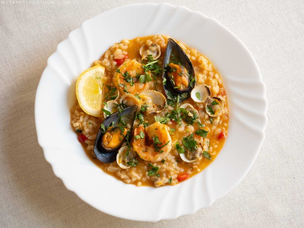 plate of Portuguese seafood stew with rice and lemon wedge.