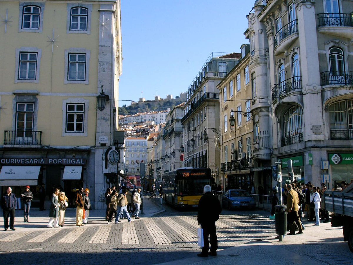 historic stone buildings on a sunny street in Lisbon.