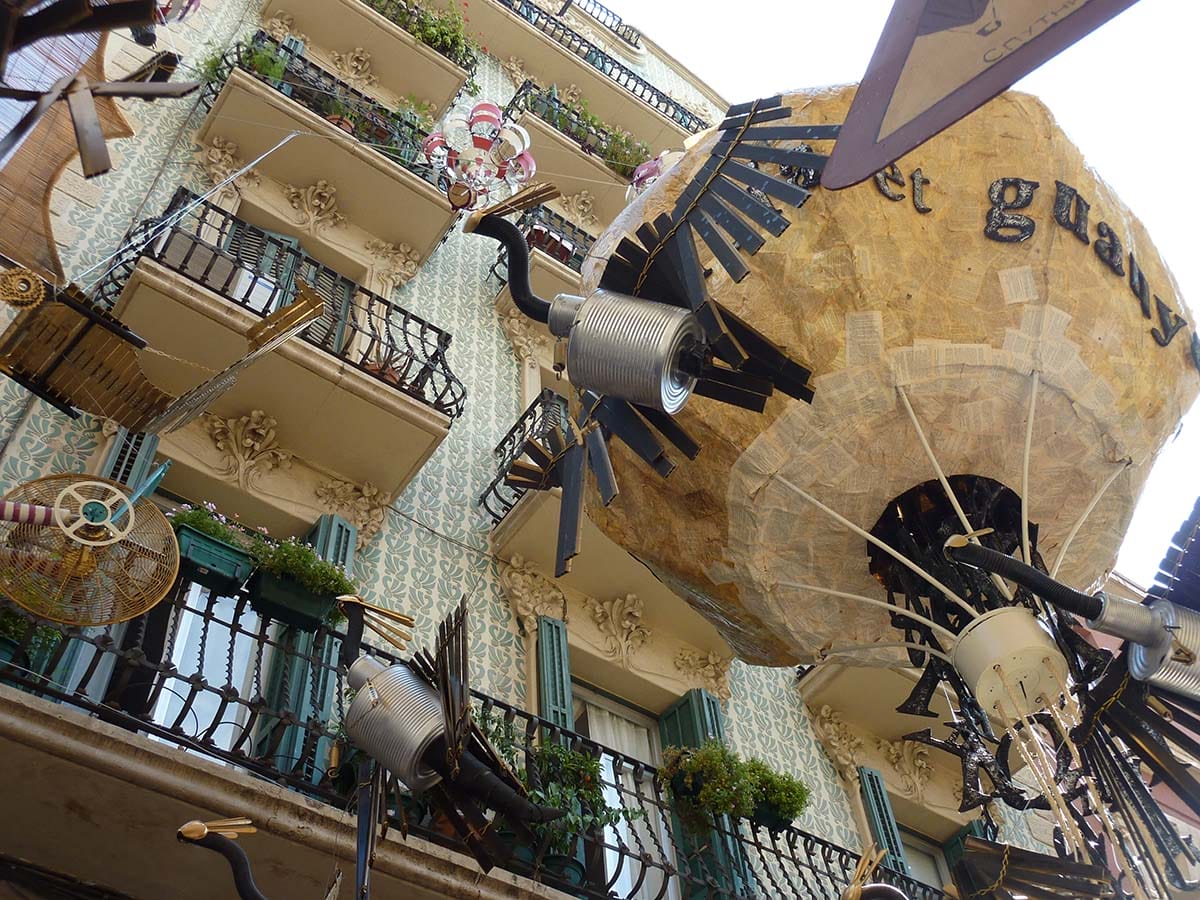 looking up from the decorated street toward balconies.