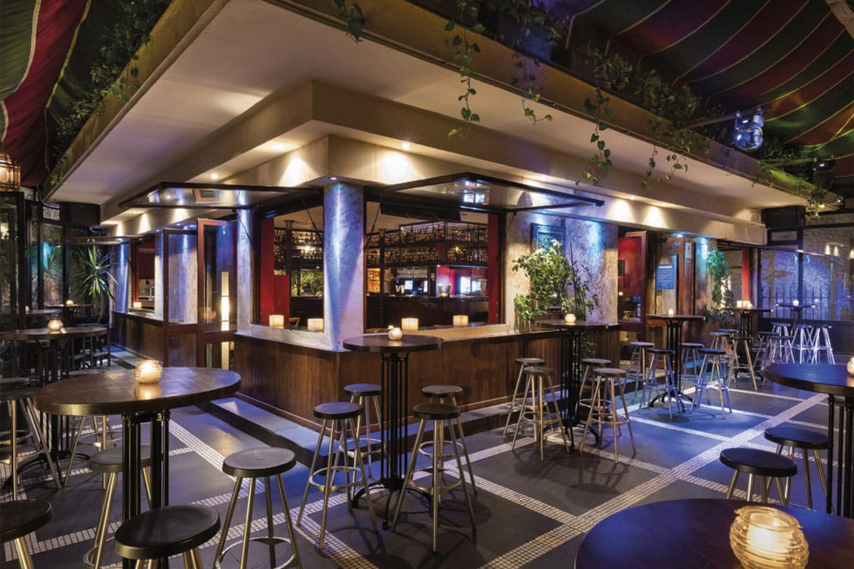bar tables and stools at a covered outdoor terrace.