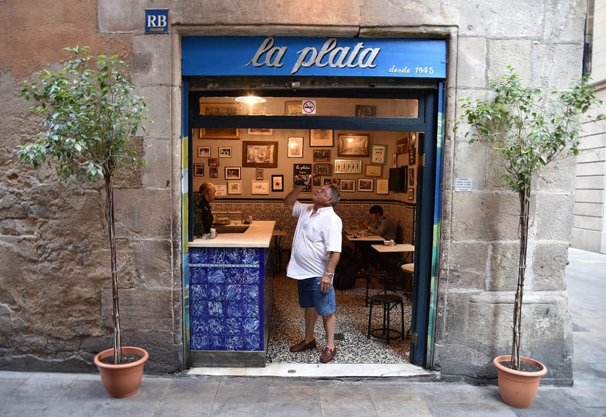 doorway leading into a small restaurant with a bar, tables, and chairs inside.