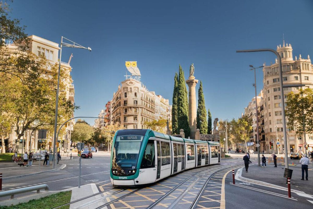 Barcelona tram driving through a beautiful downtown area.