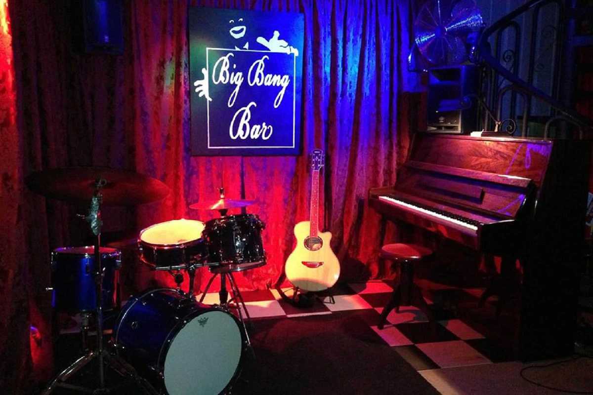 drum kit, guitar, and piano on a small stage.