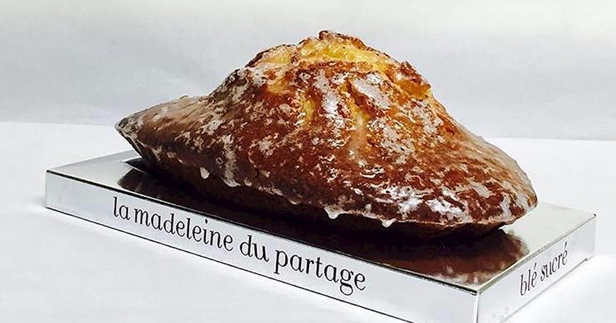 large madeleine on a shiny silver plate.