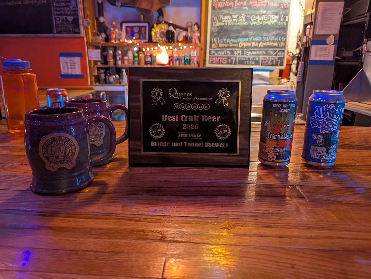 two mugs of beer with two cans of beer near a plaque naming Bridge & Tunnel the best craft beer in 2026.