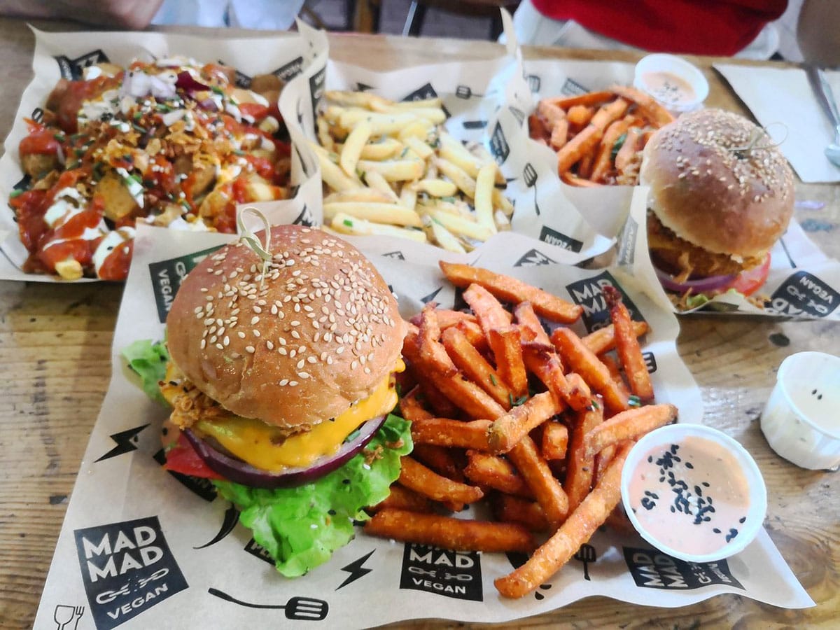 two vegan burgers with sauce and sweet potato fries.