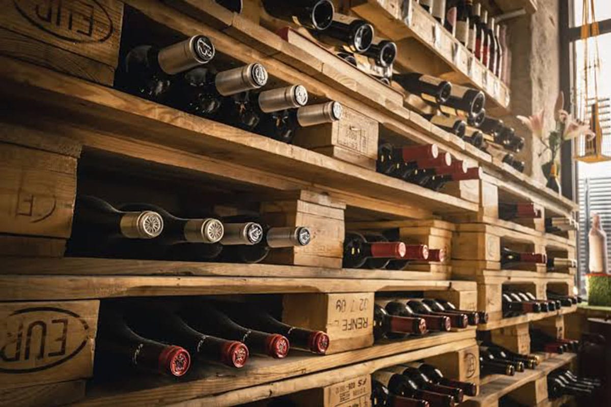 shelves of wine bottles in wooden pallets.