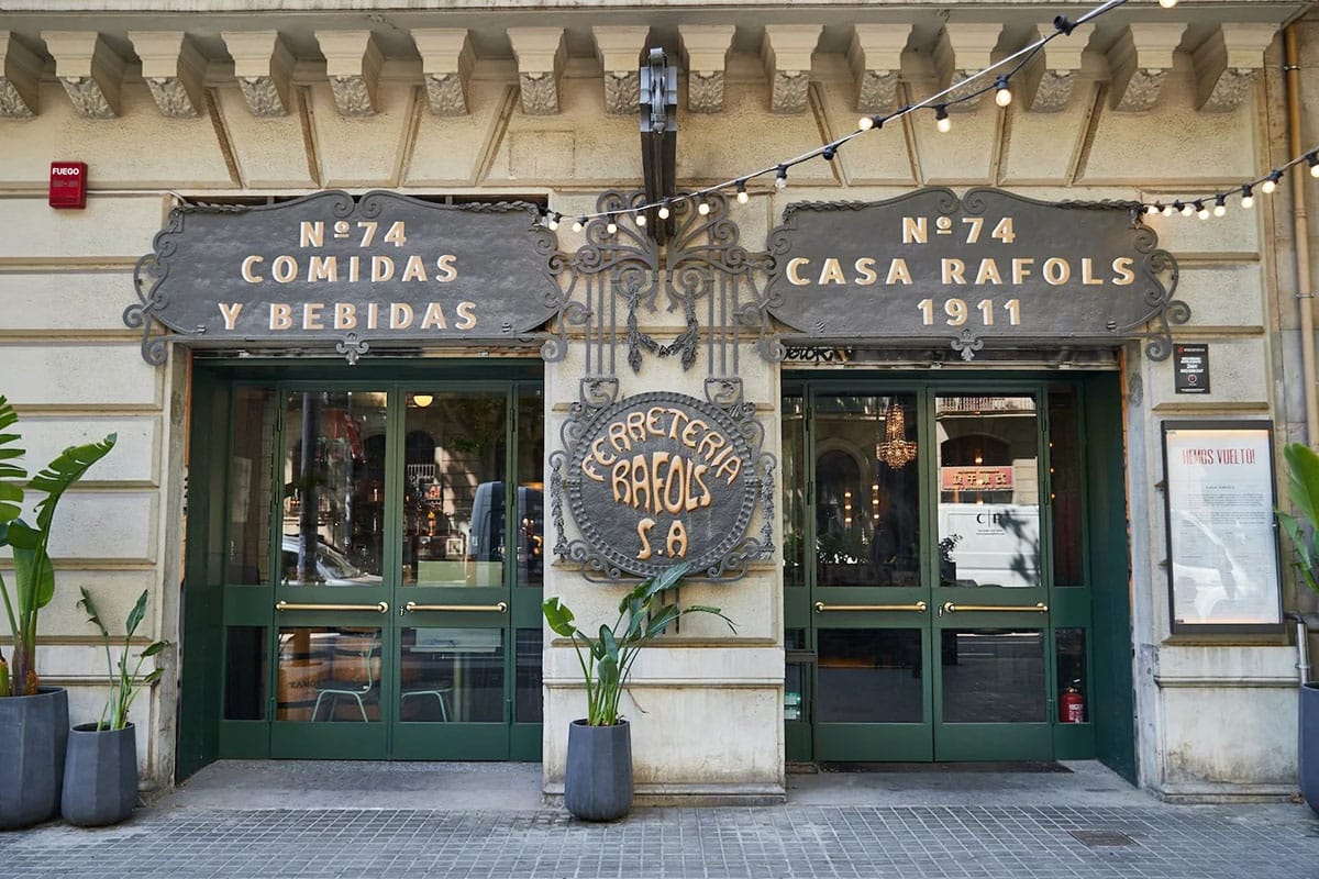 two green double doors leading into a stone building housing a restaurant.