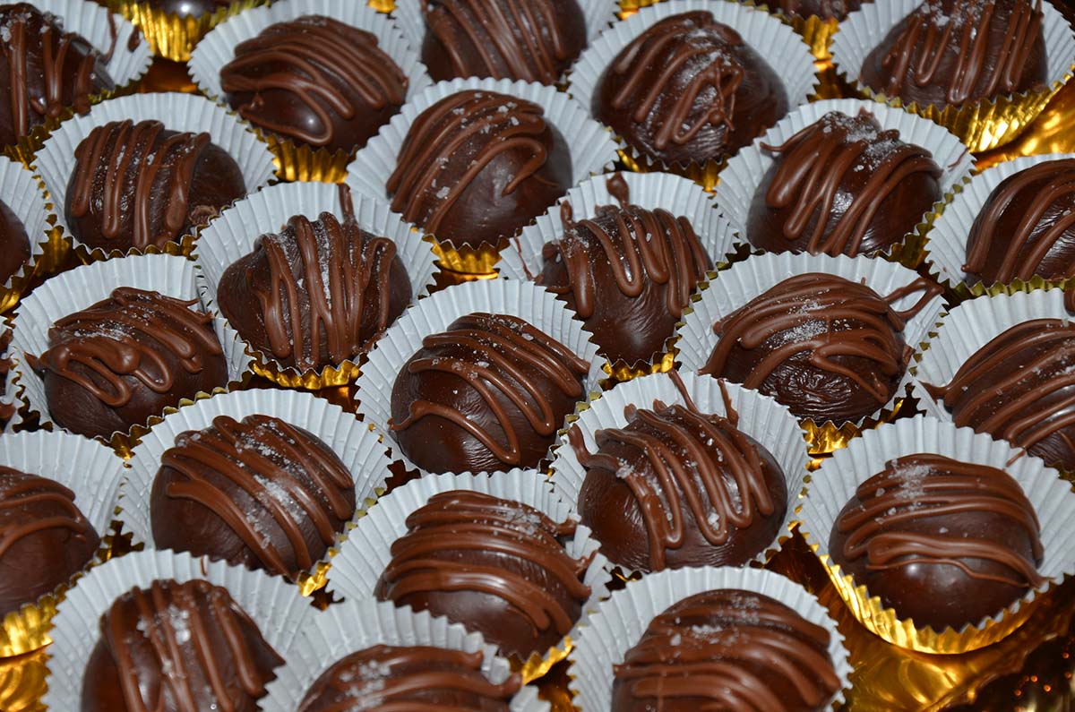 dark chocolate truffles drizzled with milk chocolate and placed in paper cups.