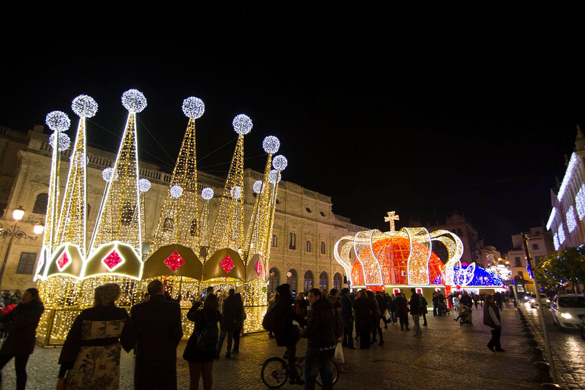 large illuminated crowns for the three kings in a Seville plaza.