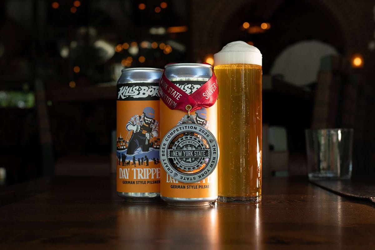 two cans of craft beer with a draft beer beside it on a wooden table.