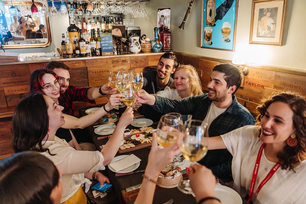 group of people toasting with wine glasses at a table.