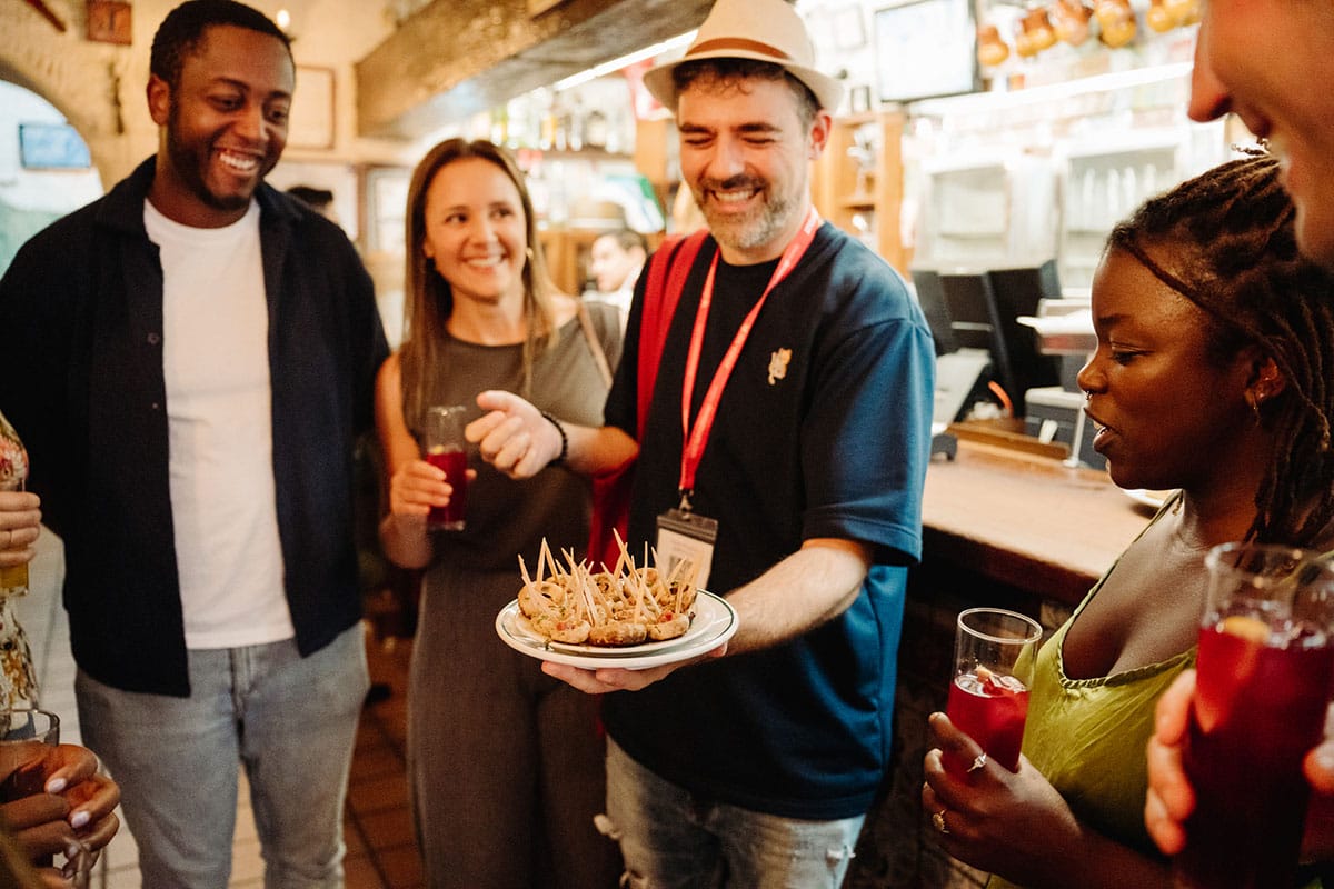 tour guide holding a plate of tapas for guests to enjoy.