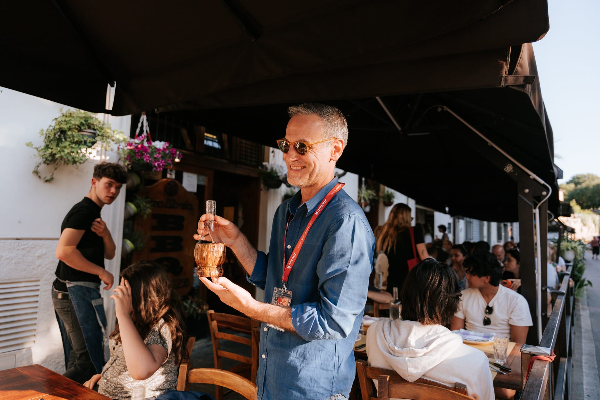 male tour guide holding a fiasco bottle of red wine.
