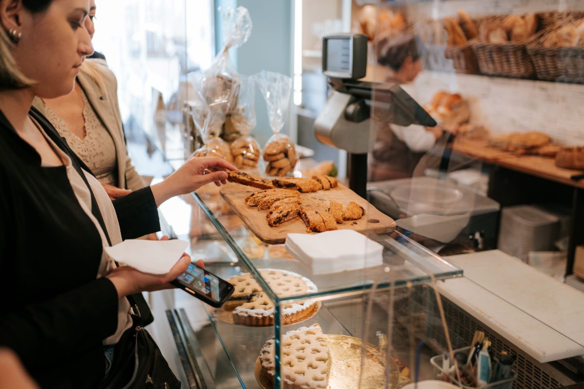 A woman taking a slice of sweet bread from a wooden board at one of the secret bakeries in Florence. 