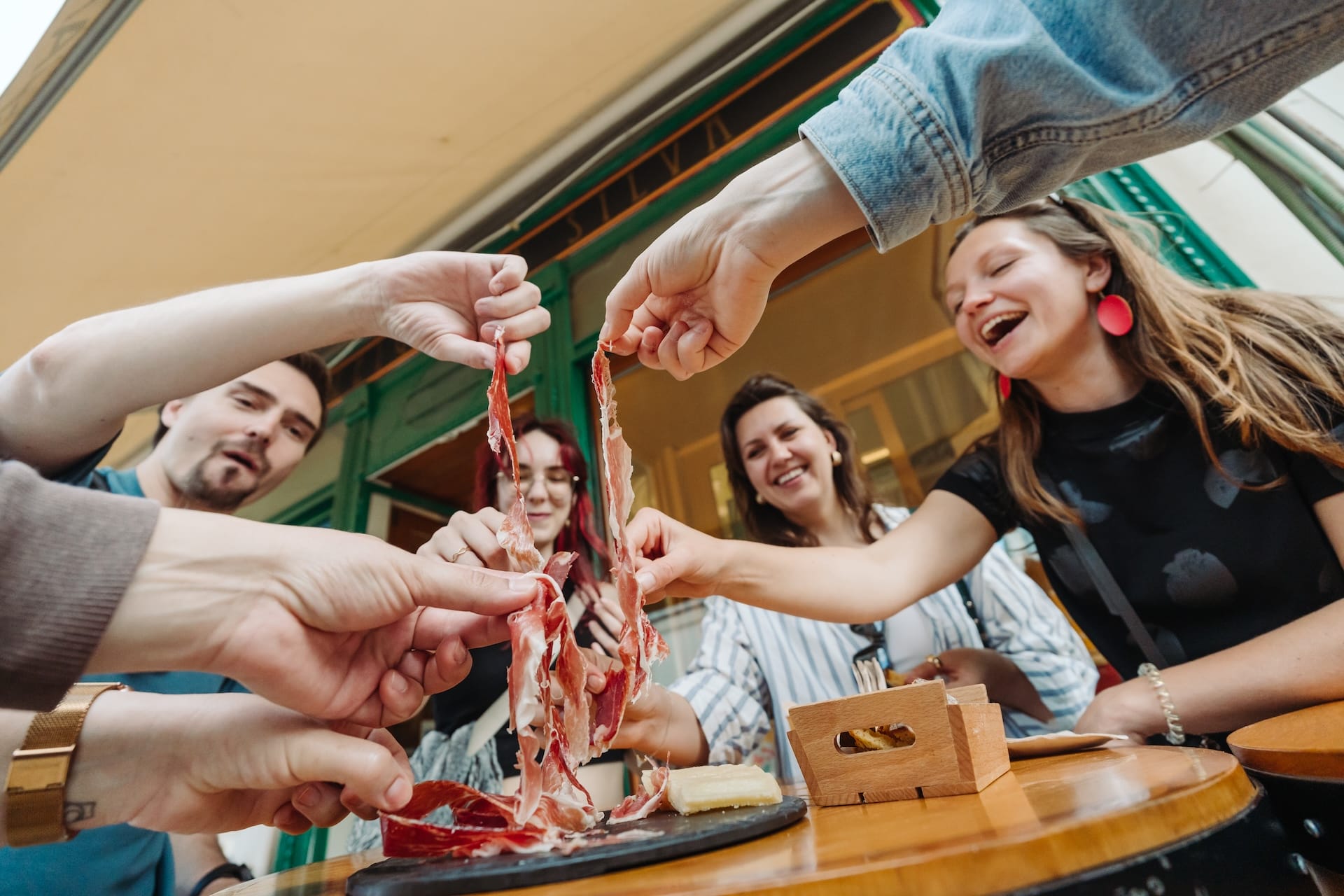 group of people eating cured ham.