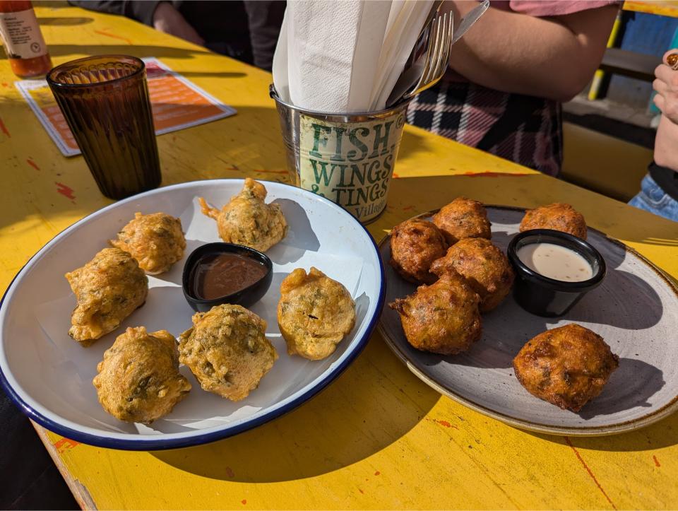 Cod fritters on two different plates outside at the London Brixton Food Market