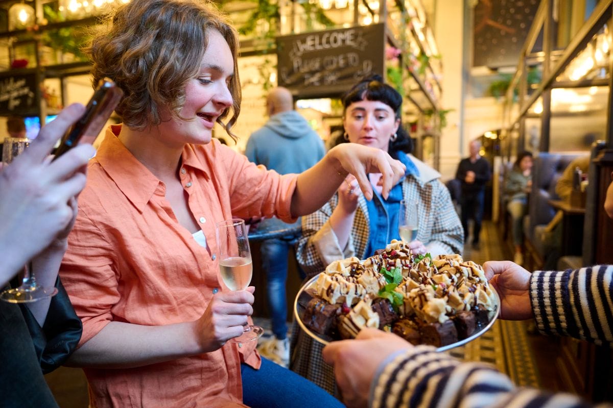 People at a bar sampling different London bites.