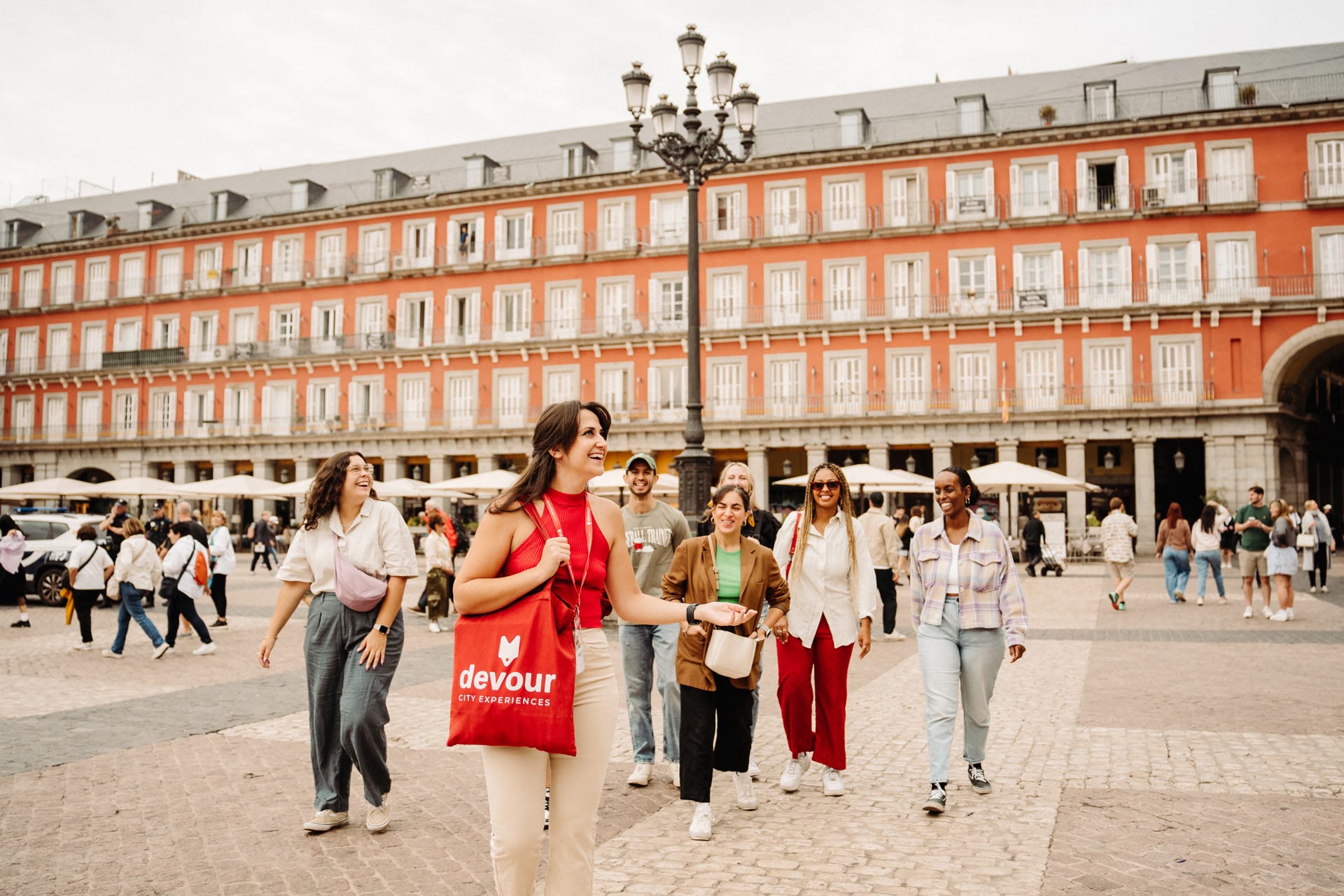tour guide leading a group of tourists through a plaza in Madrid.