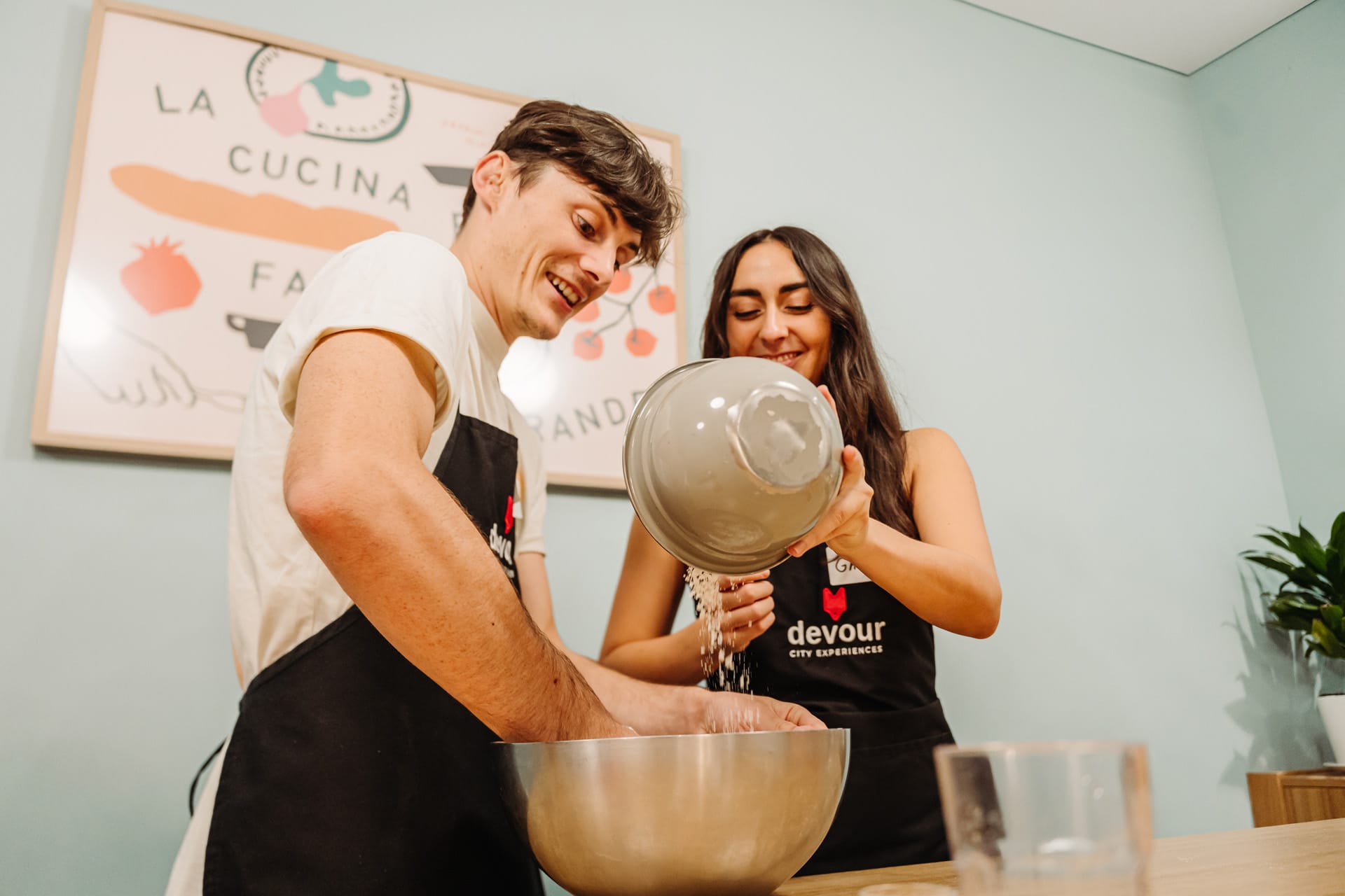 people making pizza dough in a kitchen.