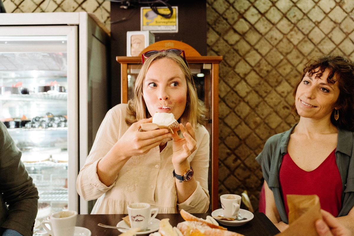 A woman eating a pastry from one of the many secret bakeries in Florence. 