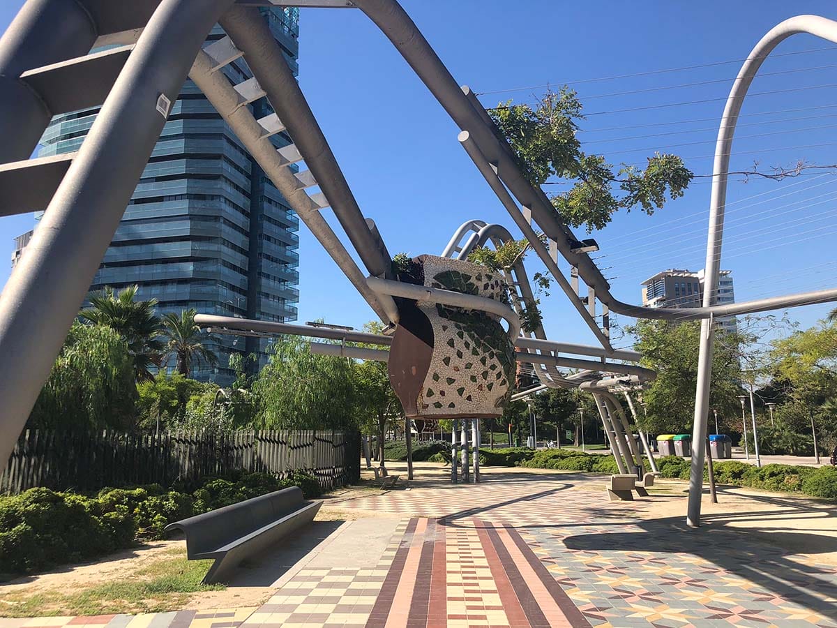 metal sculptures in a park with skyscrapers nearby.