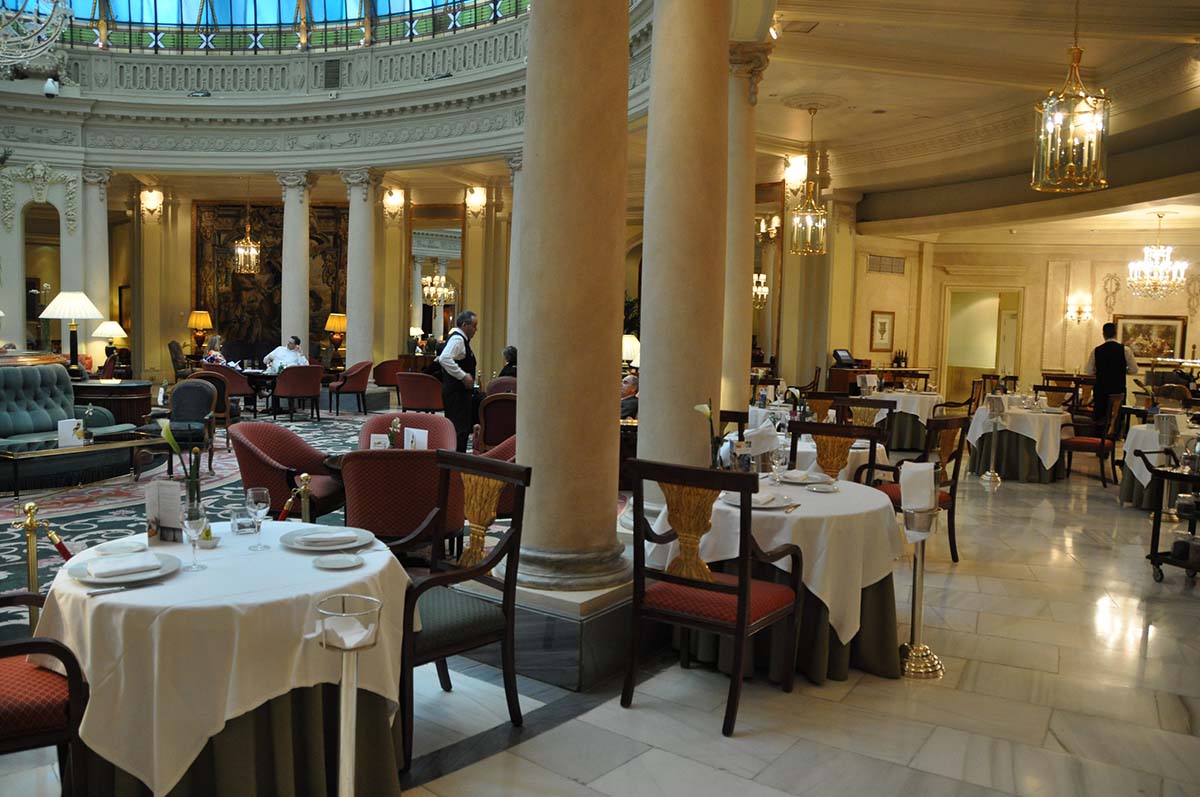 dining tables in a columned portico in a hotel.
