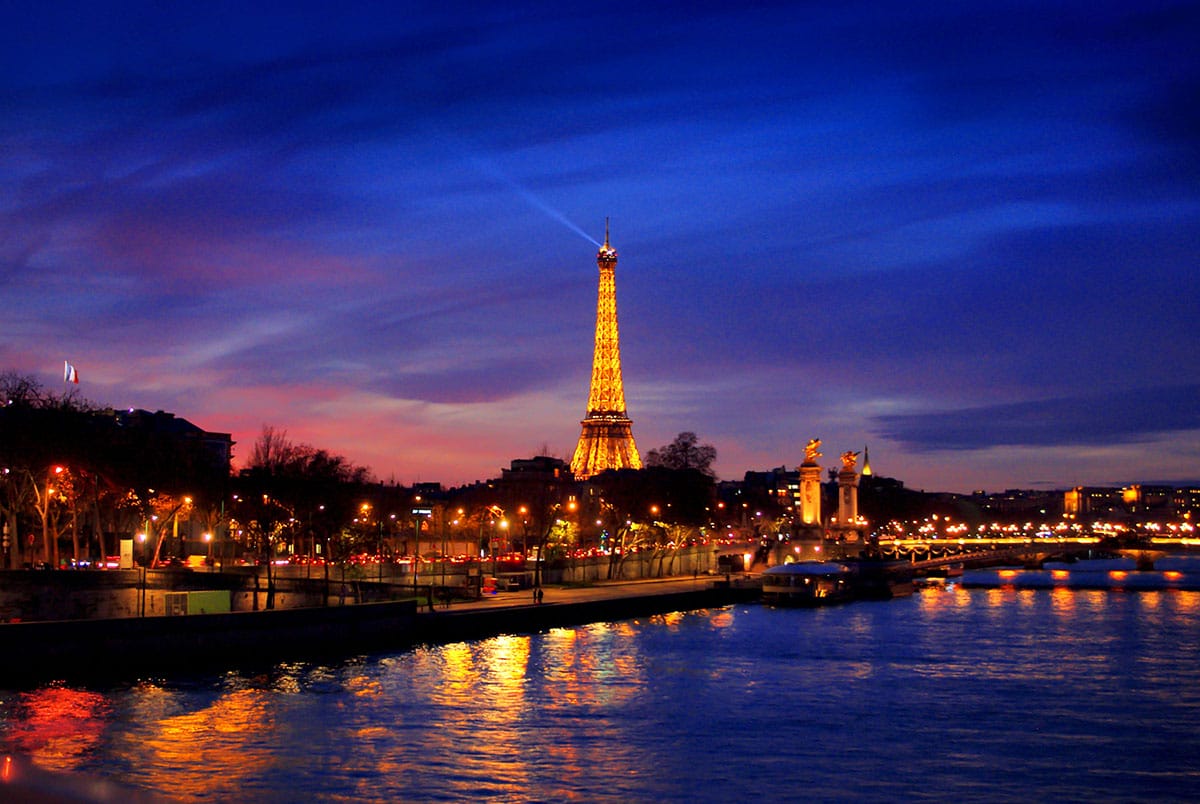 Eiffel Tower at night overlooking the Seine River.
