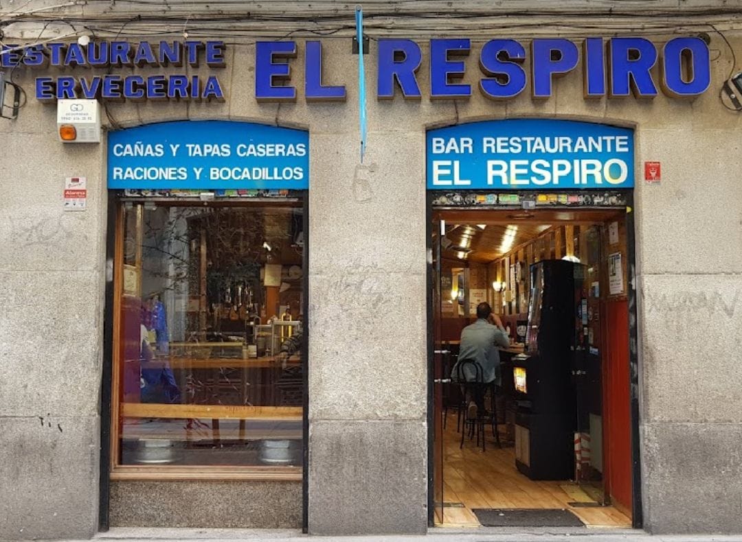 building with a large window and door and a sign that says "El Respiro".