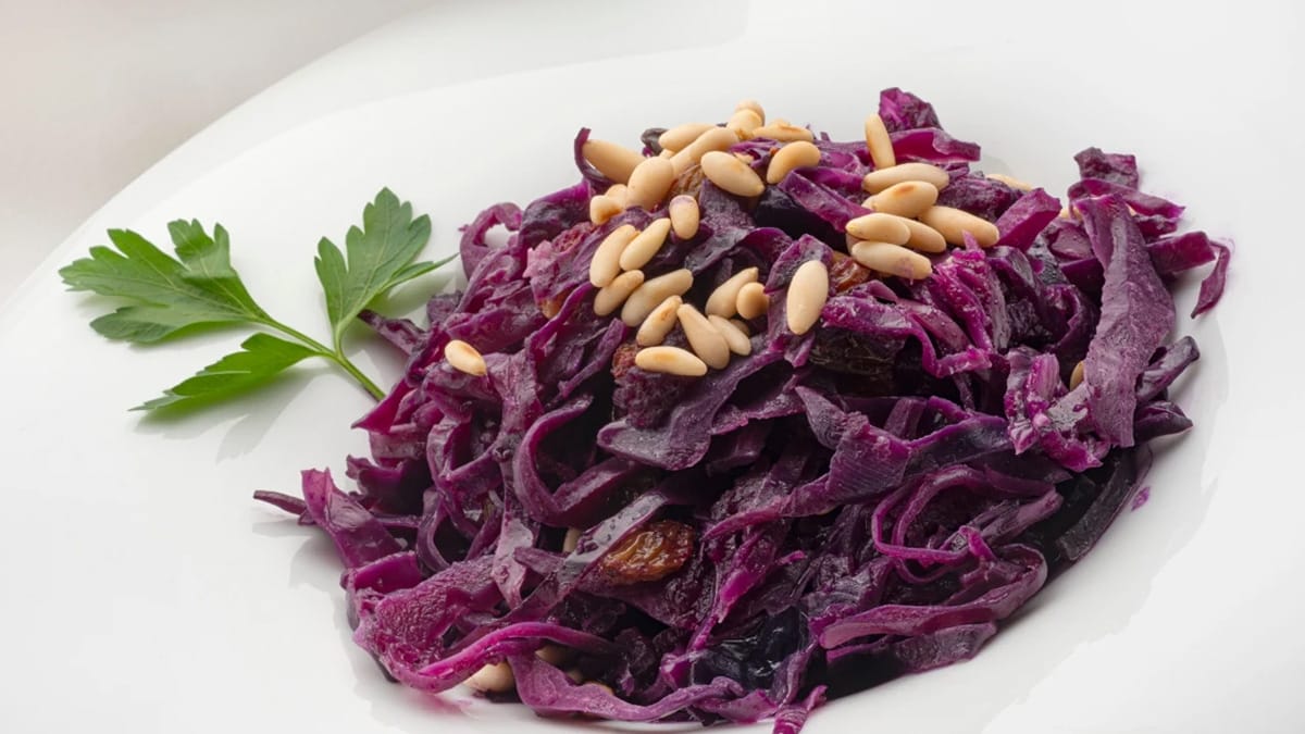 plate of shredded red cabbage topped with pine nuts.