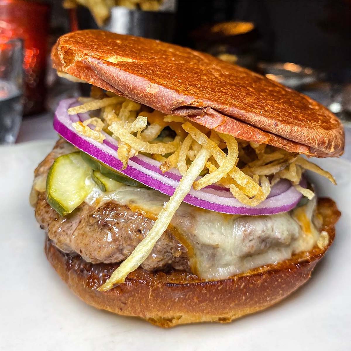 upside-down burger with crispy fries and a cheese-topped patty.