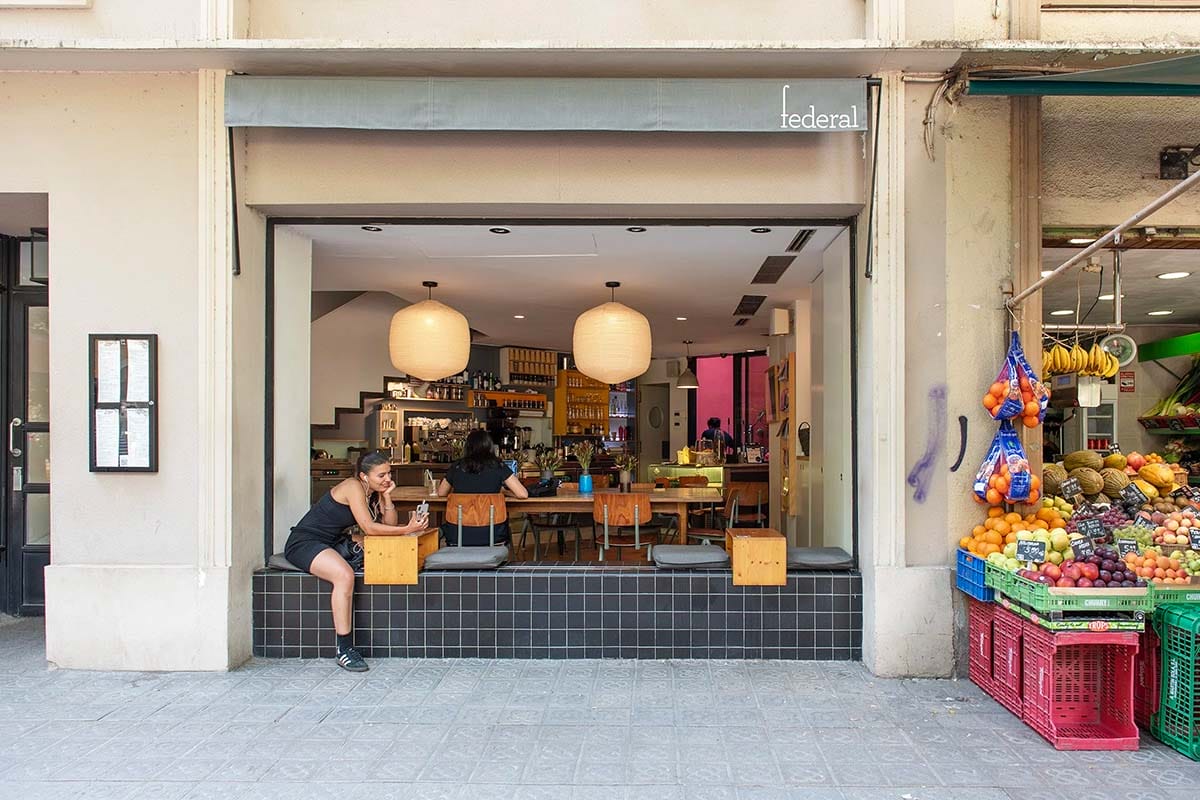 woman sitting on an outdoor seat at a café.