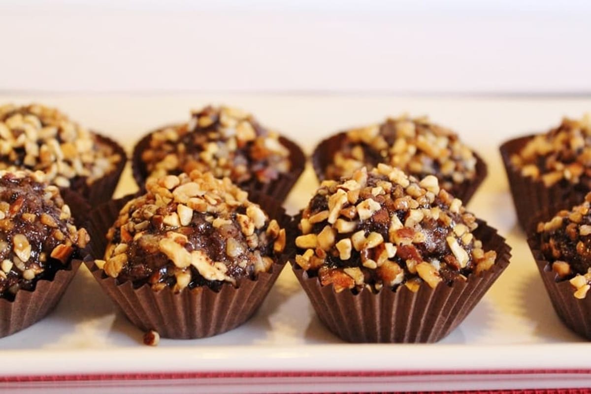small balls of pork sausage coated in chopped nuts and placed in paper cups.