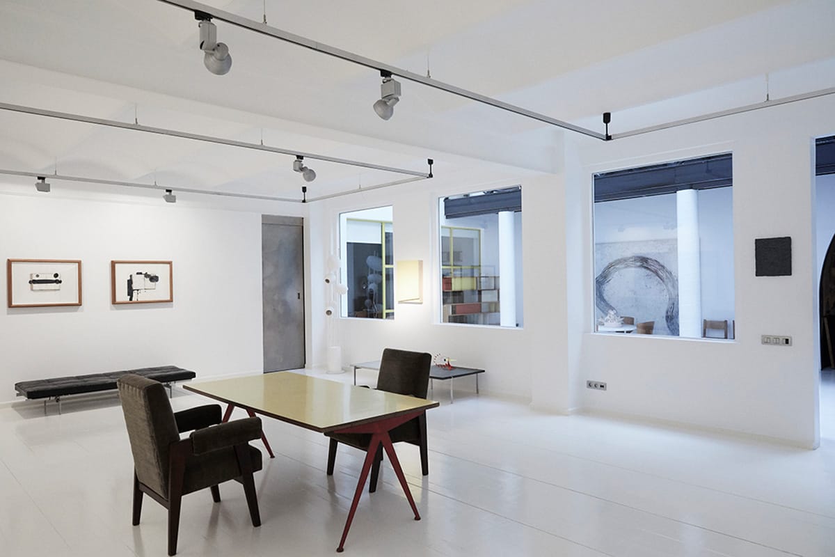 table and chairs in the center of an art gallery.