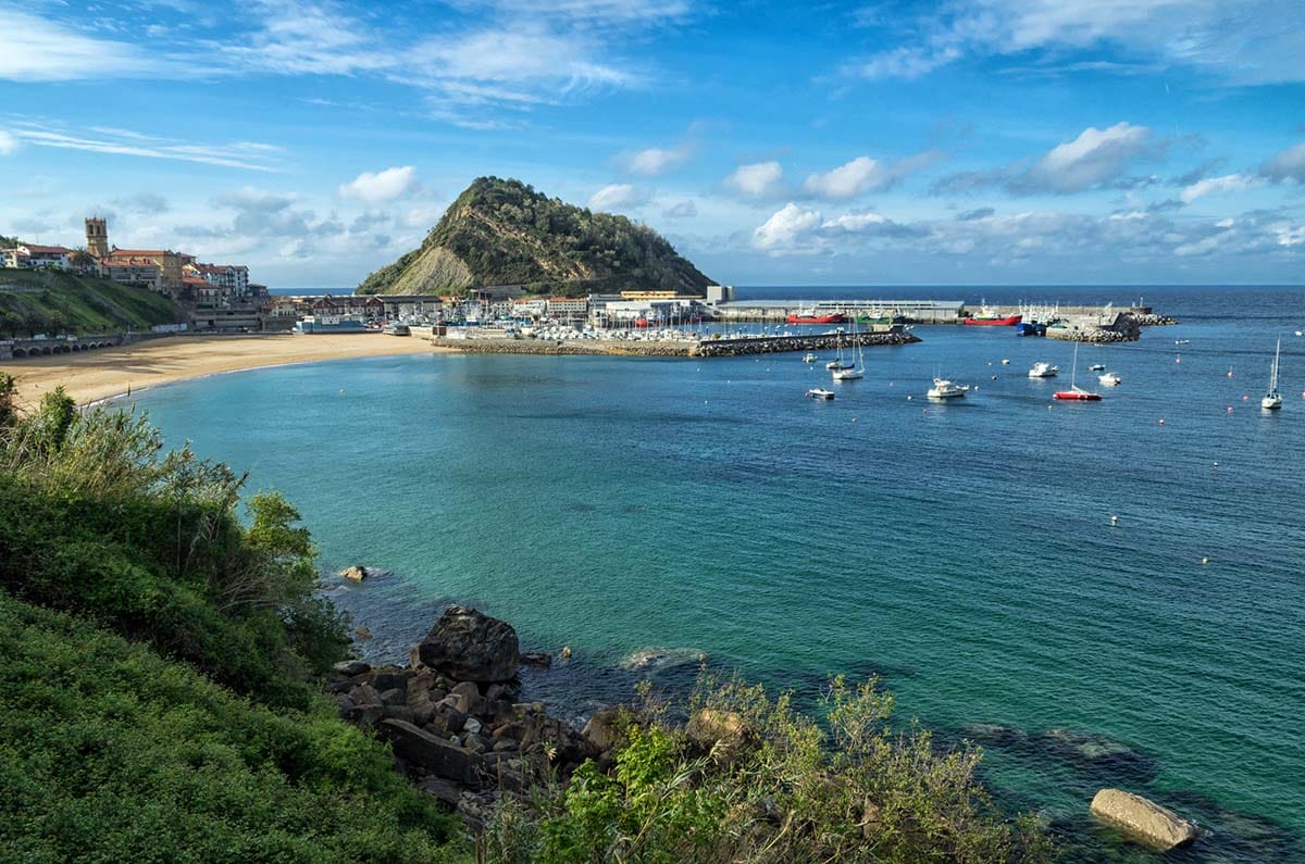 stony coastline with a beach overlooking a natural harbor and the ocean.
