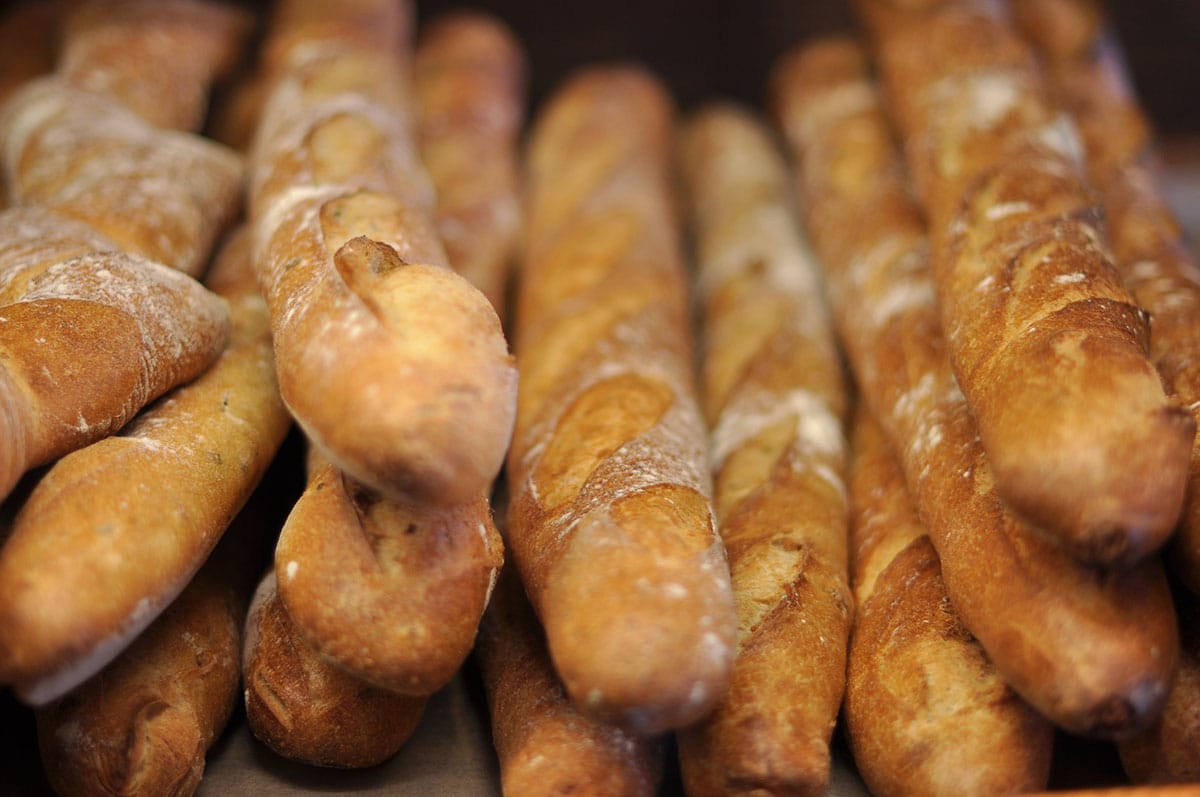 stack of long, thin golden brown baguettes.