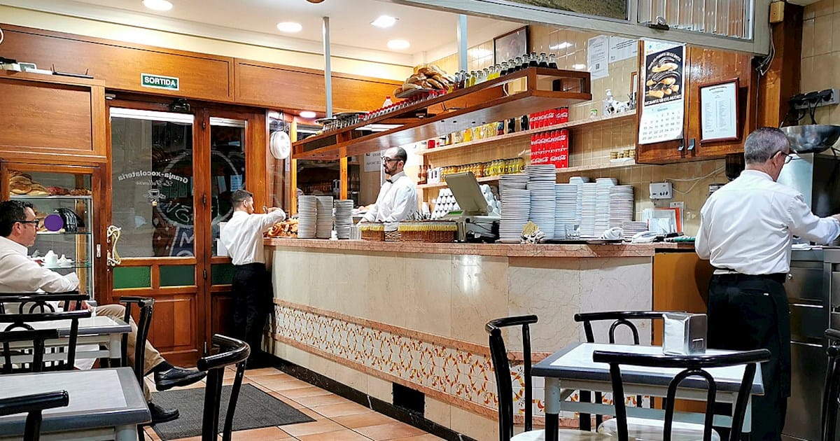 three waiters making and serving hot chocolate.