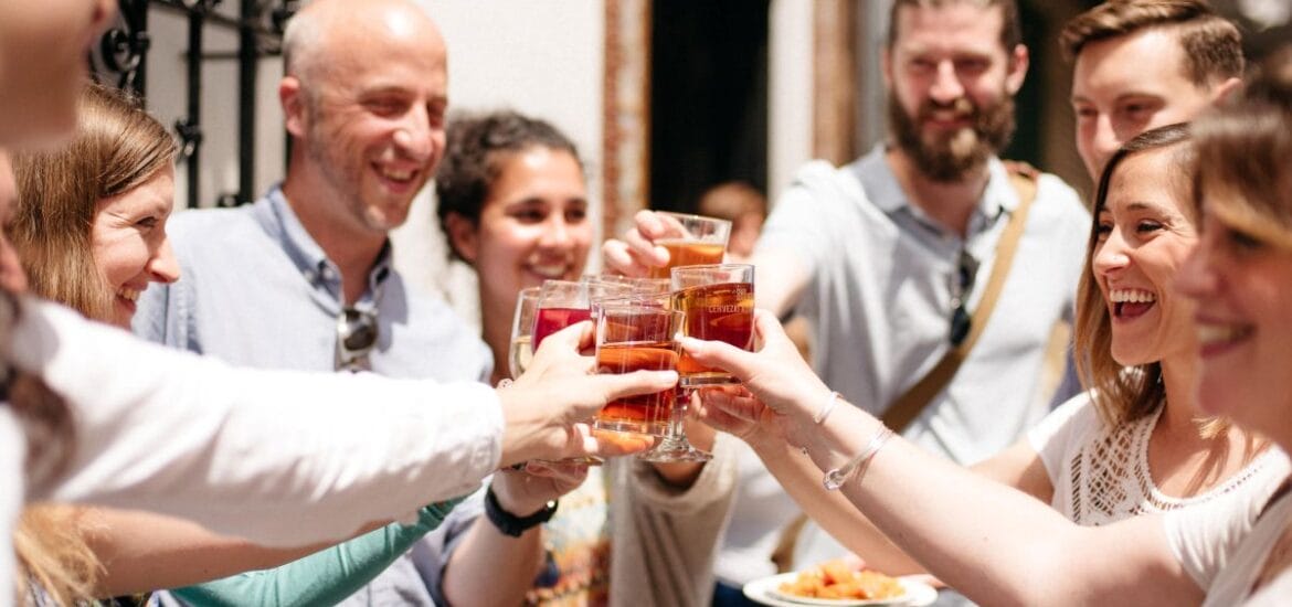 group of people smiling and toasting with glasses.