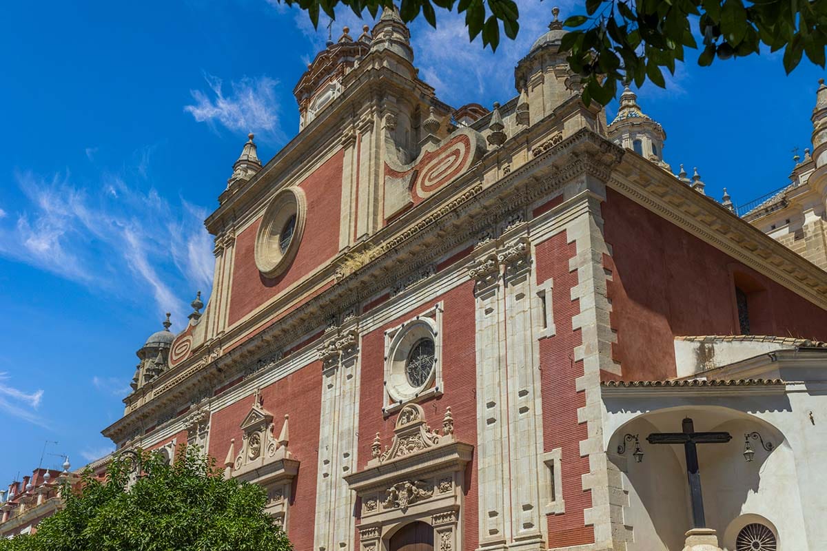 the impressive exterior of a church with red brick and ornate doorways.
