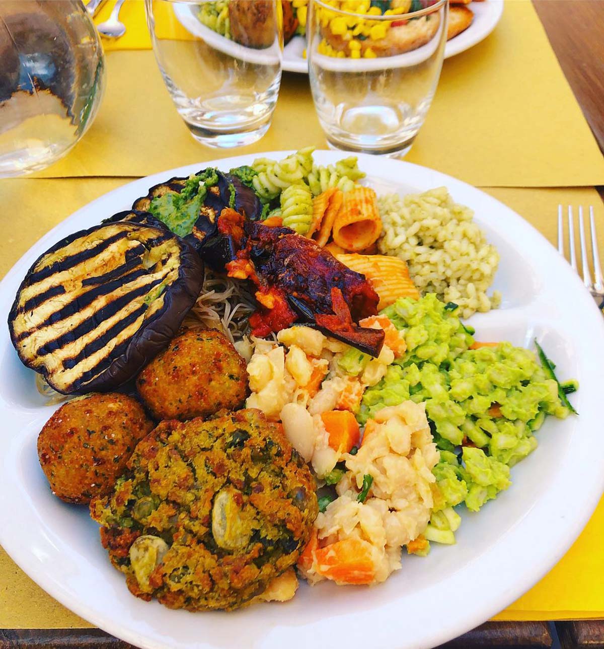 white platter of colorful vegetarian food.