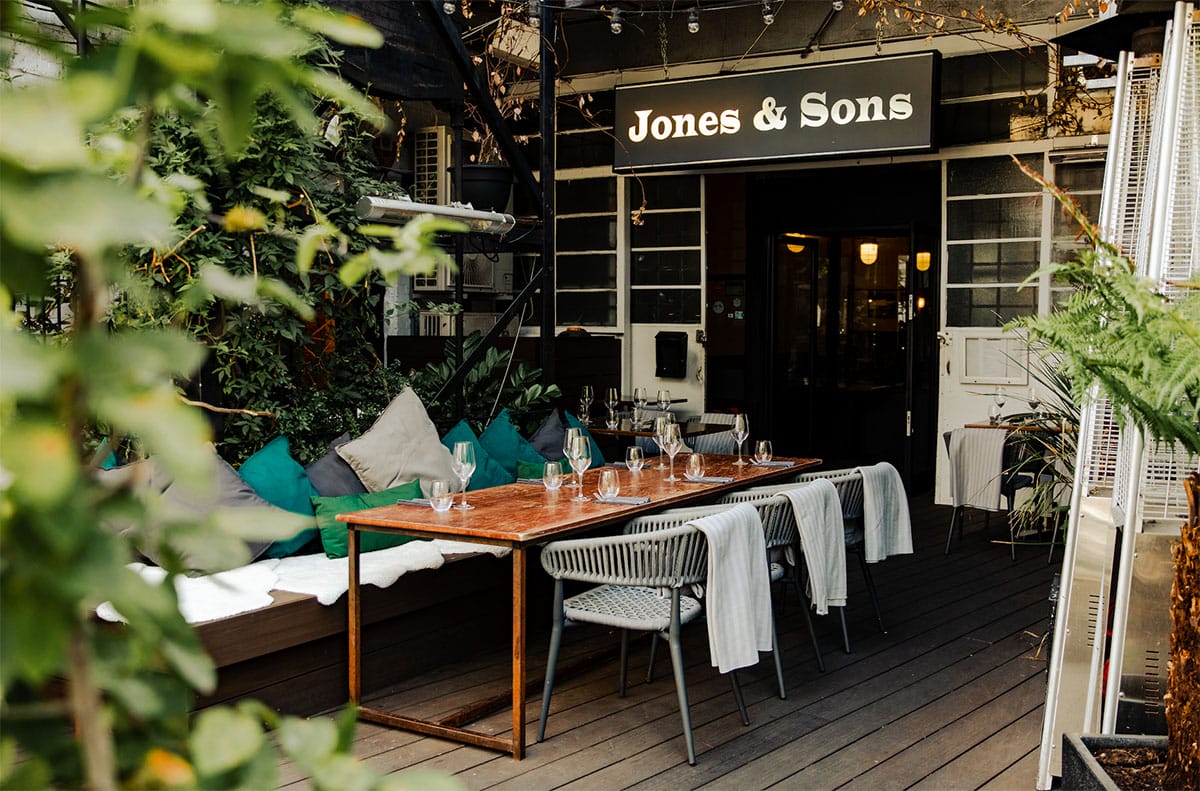 tables and couch on a patio of a bar and restaurant.
