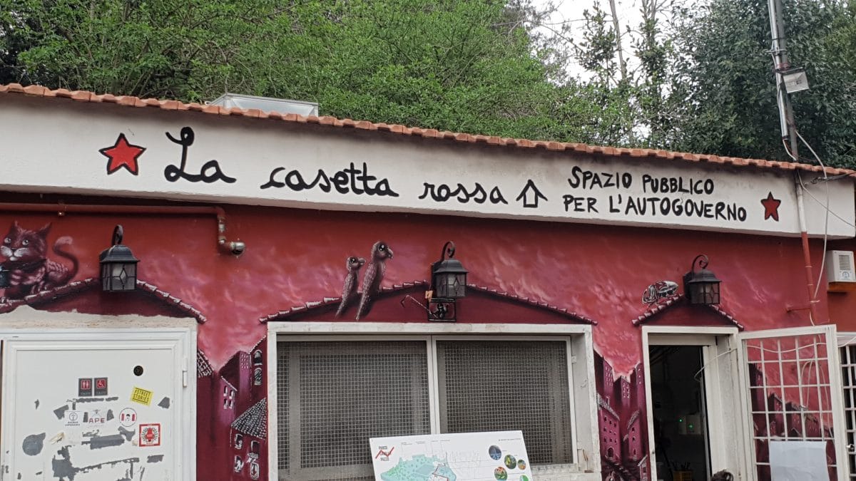 exterior of a red building with windows, a door, and a tiled roof.
