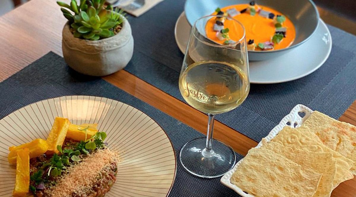 supper for two with white wine and flatbread on a white plate.